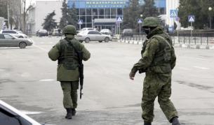 Мъже във военни униформи без опознавателни знаци патрулират край летището в Симферопол