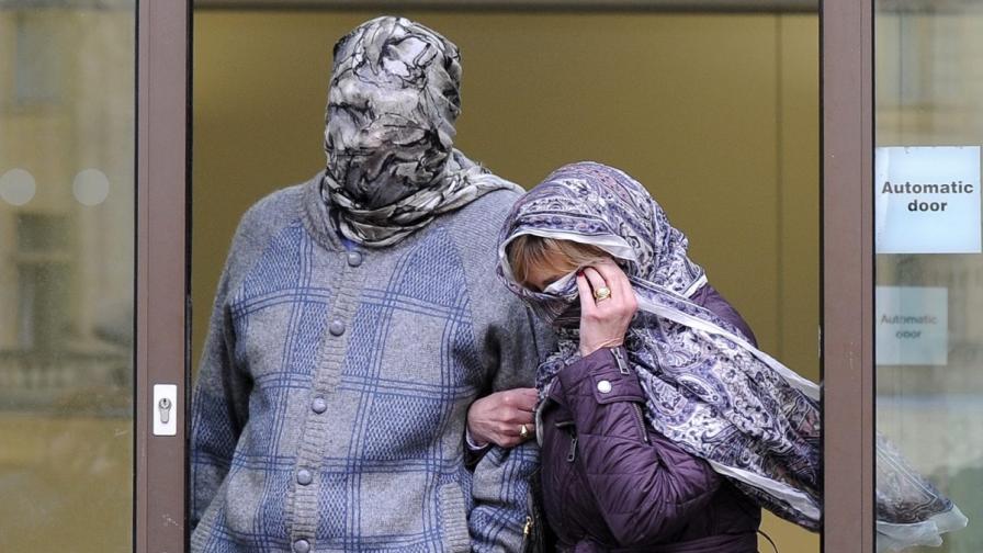 Доменико Ранкадоре и съпругата му излизат от съда, като крият лицата си зад шалове