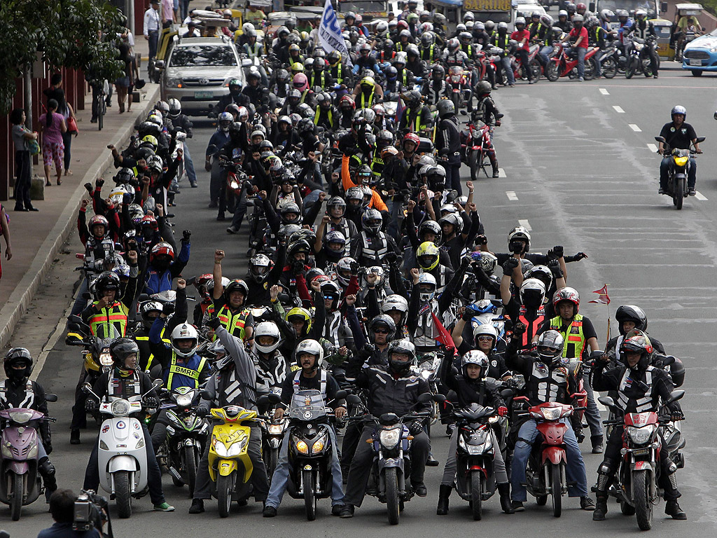 Мотоциклетисти протестират в Кесон Сити, източно от Манила, Филипините. Хиляди мотоциклетисти се противопоставят на закона който изисква мотористите да носят жилетка с отпечатани номера на гърба си.