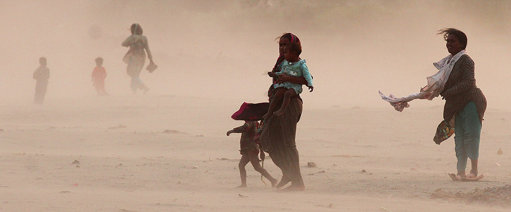 Пакистански хора търсят подслон по време на пясъчна буря в Лахор