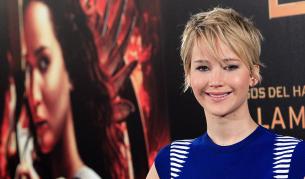 Дженифър Лорънс пред плакат на един от филмите в поредицата