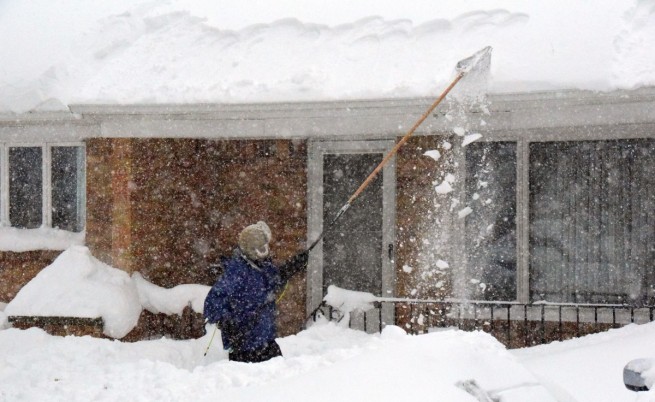 Хората започнаха да свалят тежкия сняг от покривите си