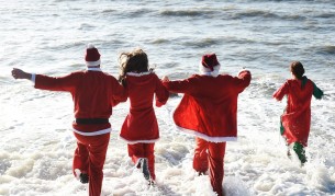 Традиционно къпане с коледни костюми на плажа в Брайтън, Великобритания