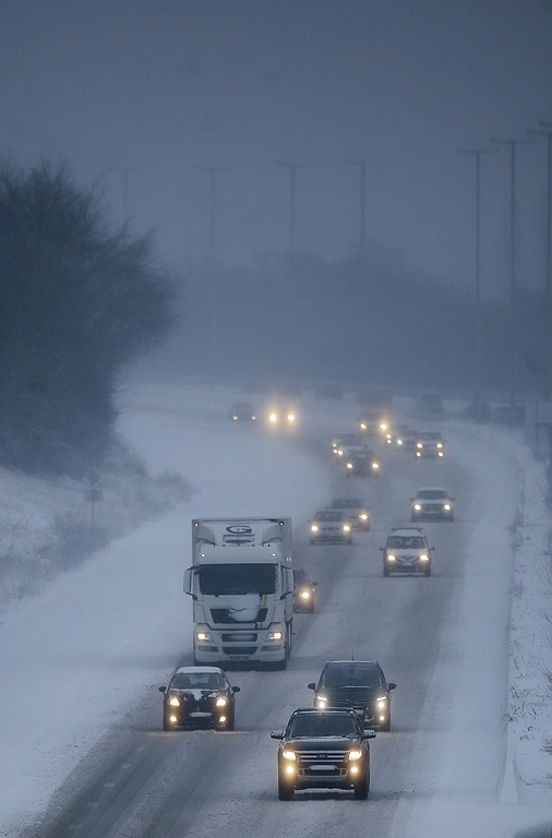 Коли и камиони по магистрала Е42 се движат по снежна покривка и намалена видимост, в района на Намюр, Белгия. Е42 свързва северна Бавария в Германия с френския крайбрежен град Дюнкерк, през региона Валония в южната част на Белгия