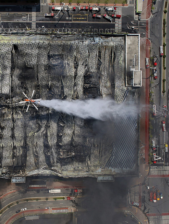 Хеликоптер пръска с вода на изгорял склад за облекла в Гимпо, западно от Сеул, Южна Корея.