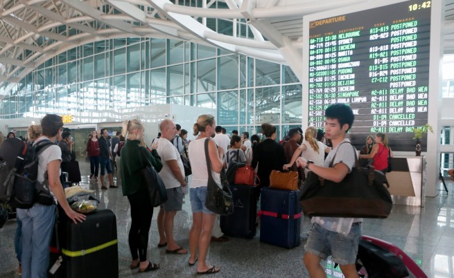 Пътници очакват информация за полетите си на летището в Бали