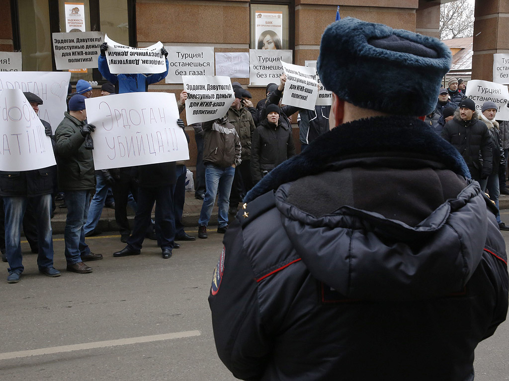 Руснаци държат плакати с текст "Ердоган е убиец" при протест пред турското посолство в Москва, Русия.