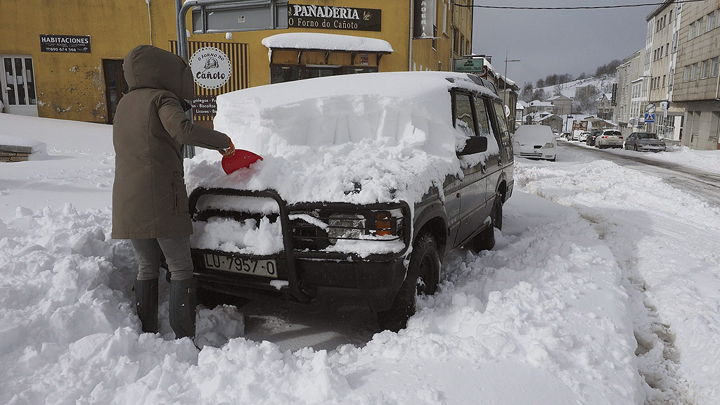 Жена почиства снега от автомобила си в Педрафита, северозападна Испания. Силни ветрове до 100 километра в час и лошо време с ниски температури се очакват в северната част на страната