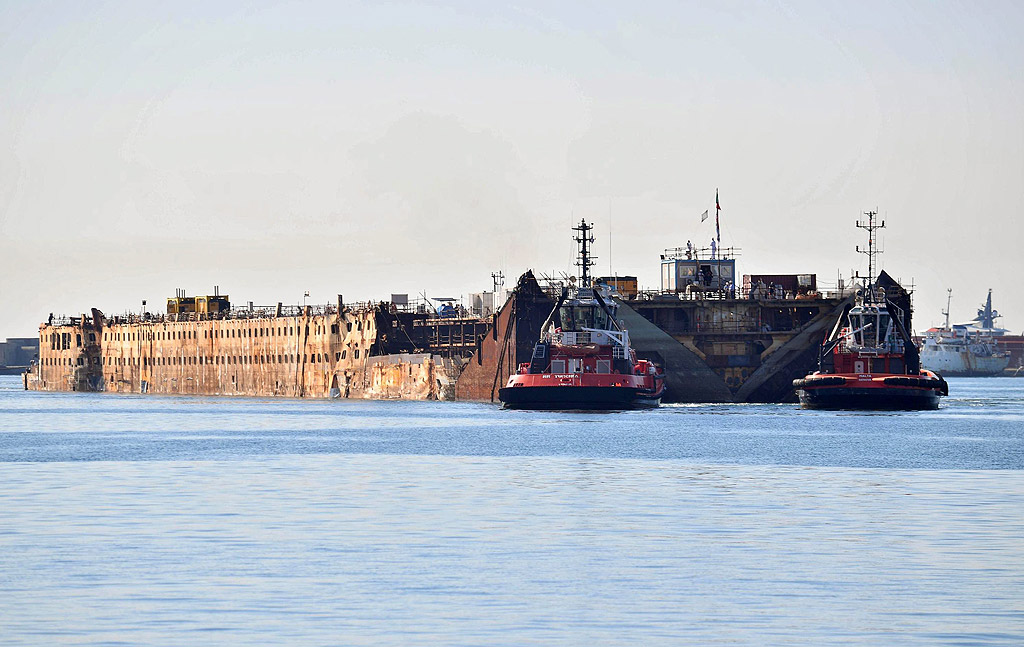 Останките на круизния лайнер Costa Concordia е теглен от пет влекача по време на последното си пътуване в пристанището на Генуа, Италия. Лайнерът, който се преобърна на 13-ти януари, 2012 ще бъде нарязан за скраб в пристанището на Генуа
