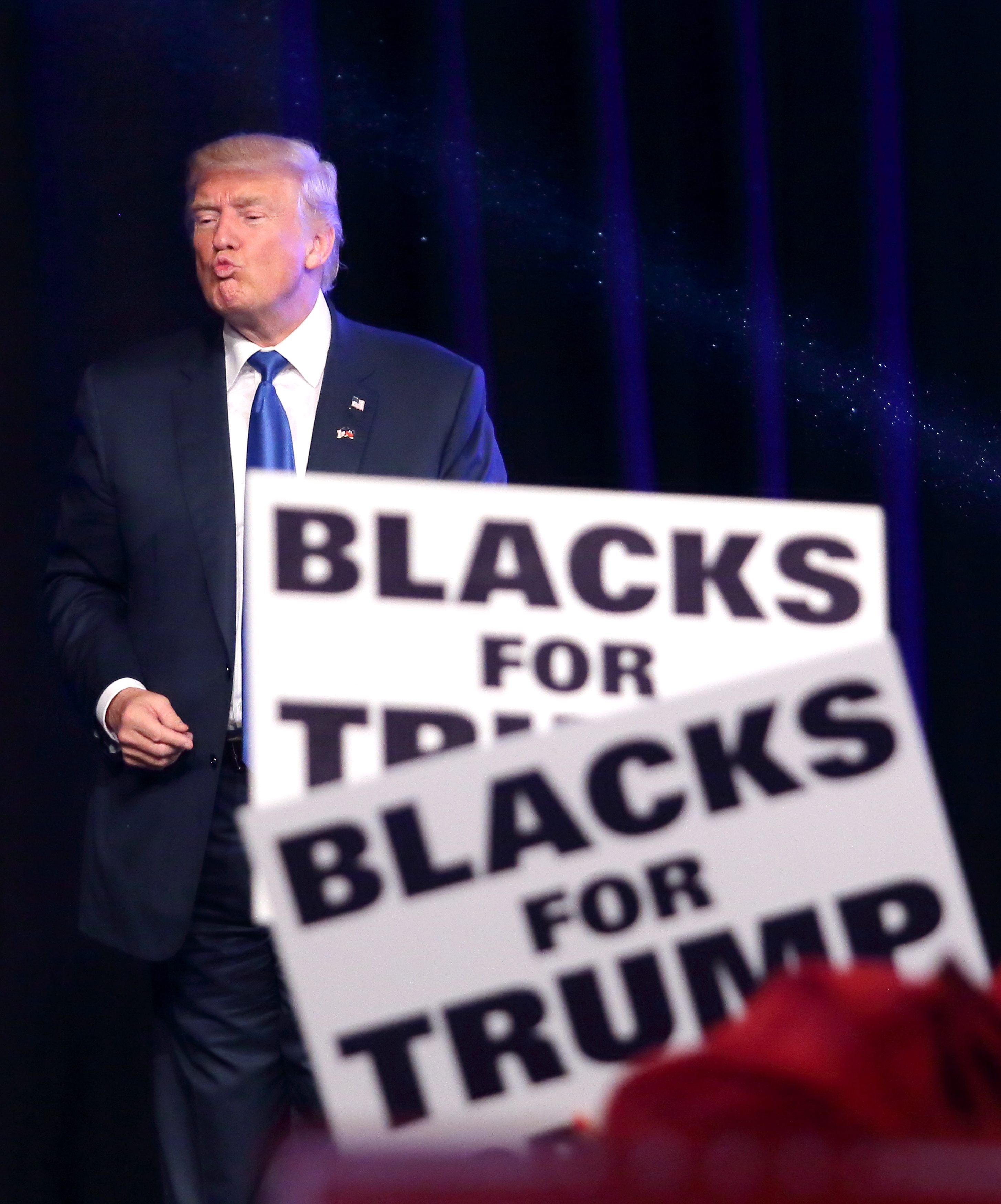 Доналд Тръмп на фона на плакати, на които пише: "Черните подкрепят Тръмп"
