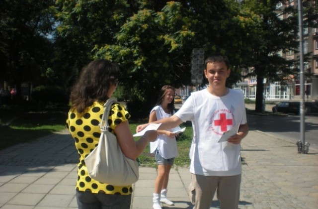 Доброволци от Младежки червен кръст раздават листовки за безопасност на движението