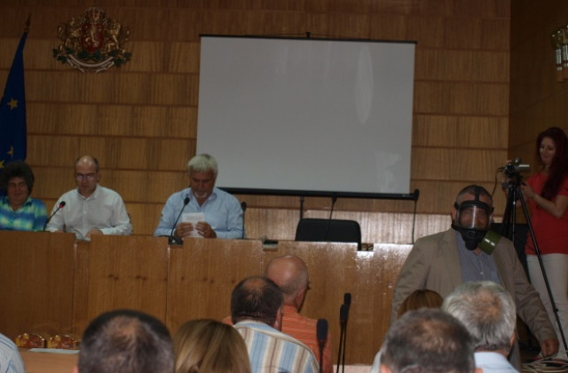 Съветник с противогаз на сесия, протестира срещу шистовия газ