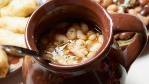 Деца варят боб в гърне на огъня в сушилото в