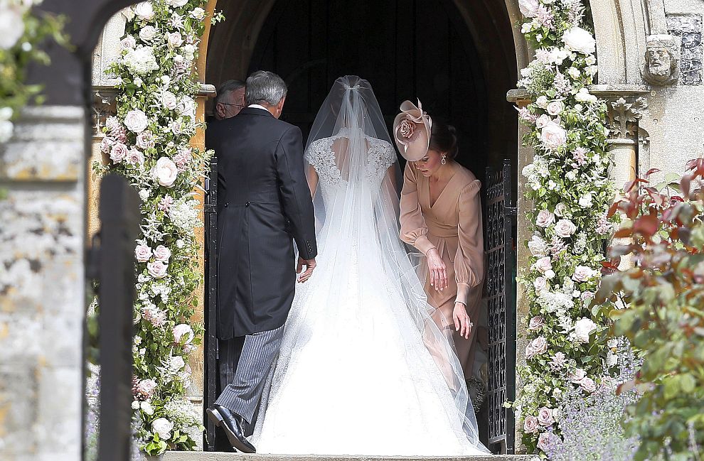Роклята на херцогинята на Кембридж Катрин беше в бледо розово. Преди началото на церемонията тя старателно оправи воала на сестра си. Майката на булката също избра розов тоалет, но в друг нюанс.