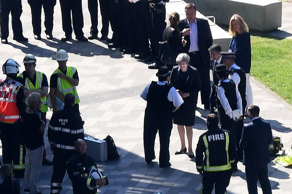  Премиерът Тереза Мей беседва с пожарникари покрай мястото на изгорелия при пожар небостъргач 