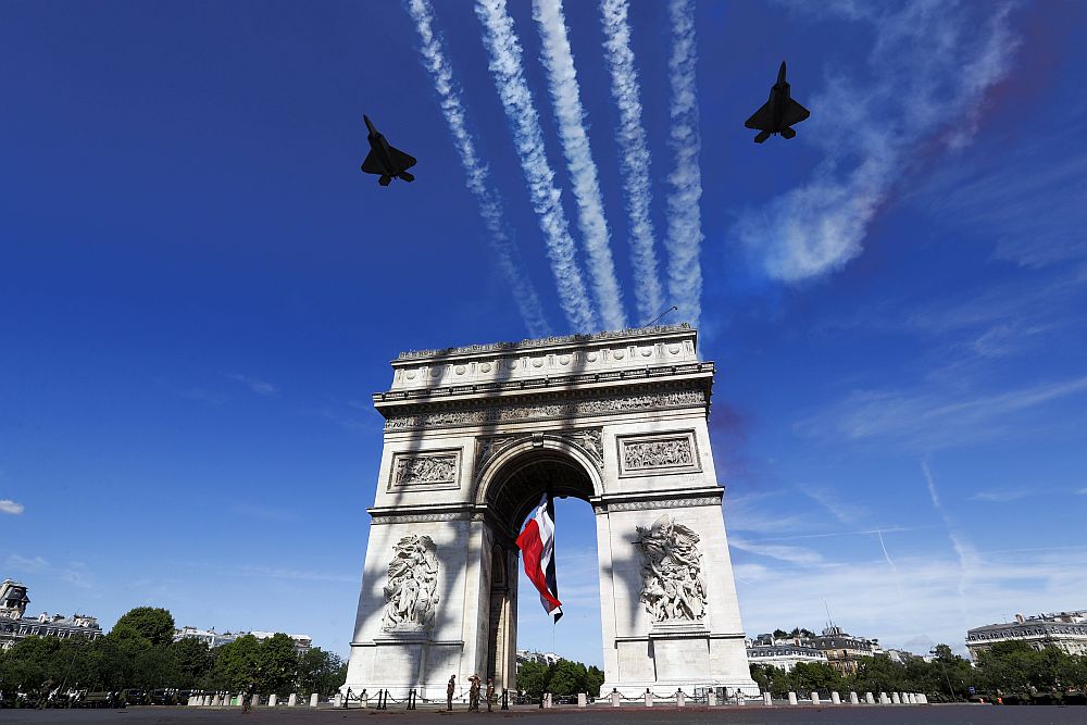 Парадът по повод френския национален празник започна с въздушно шоу на пилоти от американските военновъздушни сили, включително с два изтребителя Ф-22 със стелт технология. Заедно с тях прелетяха и самолети на френските военновъздушни сили. Мелания Тръмп бе облечена с лятна бяла рокля на цветя, а Брижит Макрон - със син костюм.
<p> </p>