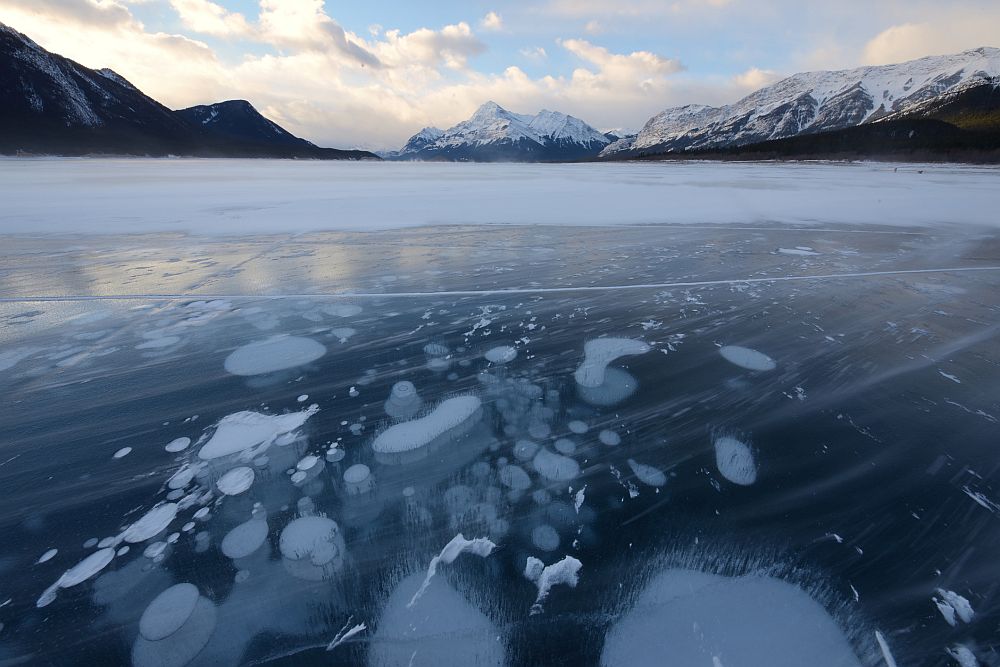 <strong>Ледени метанови мехури</strong><br>
<br>
Езерото Ейбрахам в Канада в миналото е възникнало върху суша, обитавана от много растителни видове. Разлагането на растенията в почвата непрекъснато освобождава метан, а когато езерото замръзне, метанът остава под повърхността на водата под формата на бели балончета. Те изглеждат все едно са от друг свят, като летящи чинии, паднали във водата и замръзнали след това. Други ги оприличават на древни капсулирани в леда медузи.