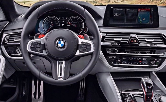  В интериора няма изненади, като нов е само скоростният лост, а върху кормилото имаме два червени бутона за избор на режимите за задвижване. 