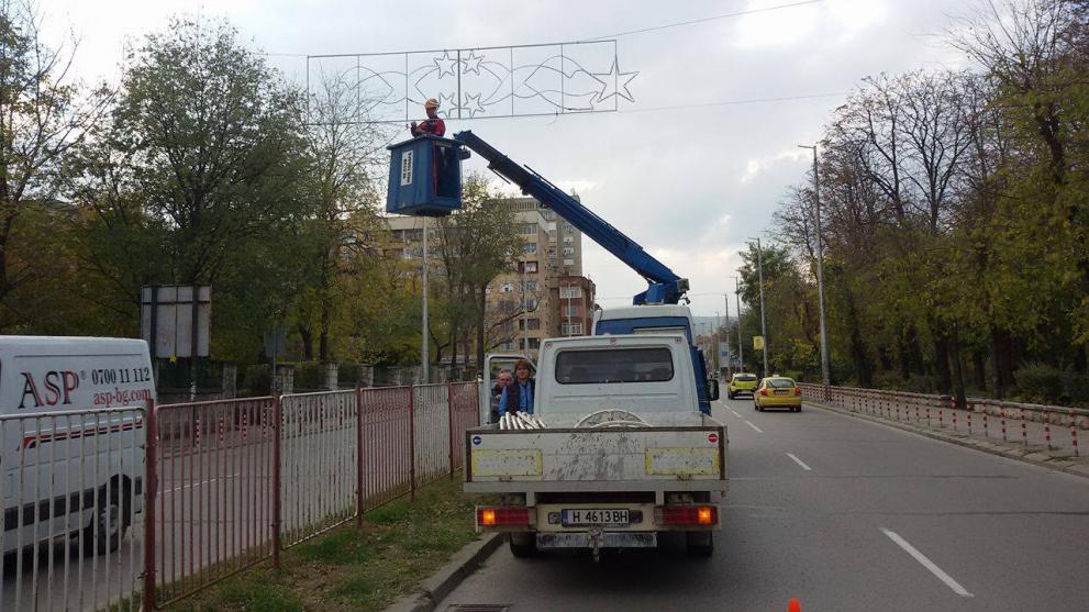 Работници поставят украсата на Руски паметник
