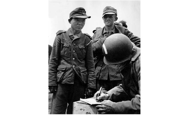  Вляво на фотографията - Ян Кьон-чон в униформа на Вермахта, хванат от американски парашутисти след десанта в Нормандия 