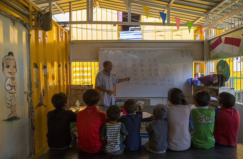 Тайландски учител от "Фондация за по-добър живот на децата" обучава децата на работниците мигранти от Мианмар, Камбоджа и Лаос на тайландски език и основни комуникационни умения.