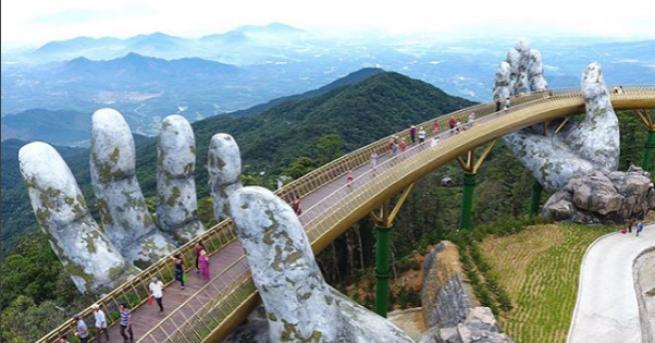 Златен мост във Виетнам обгърнат от две каменни ръце привлича