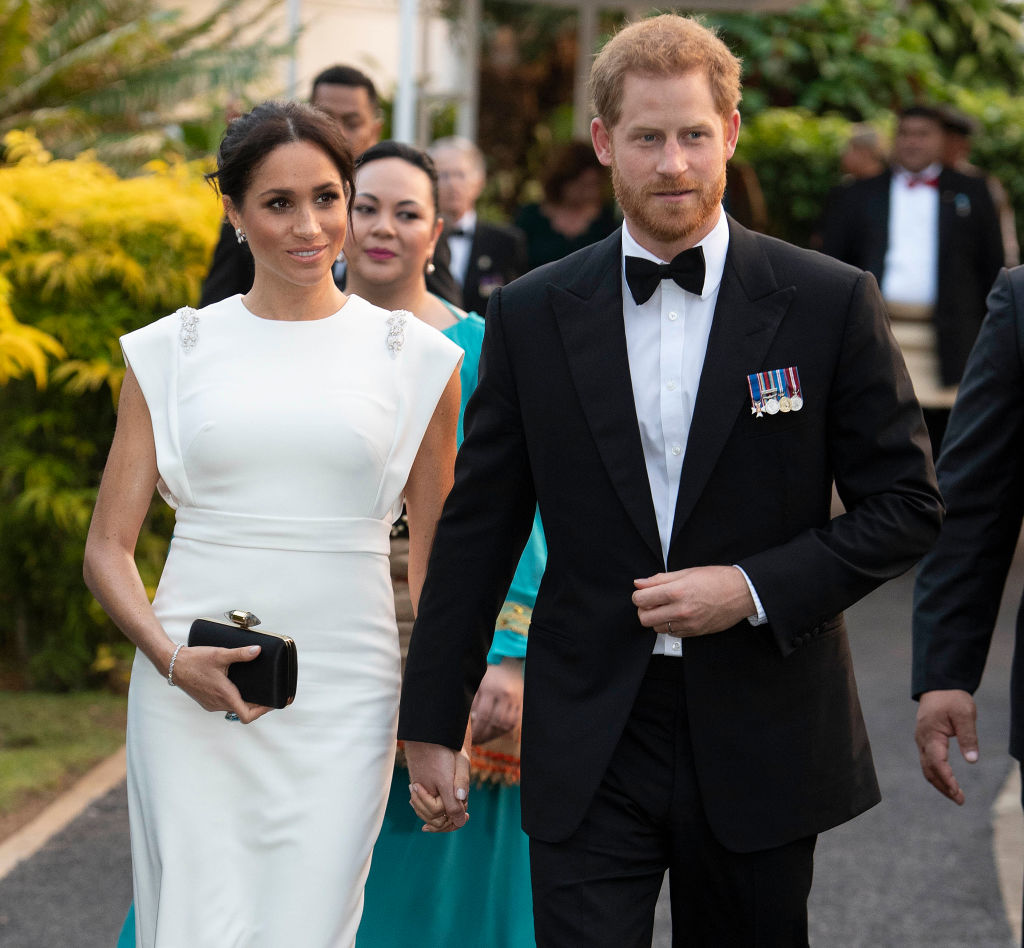 За приема с кралицата и краля на Тонга Меган бе избрала красива бяла рокля Theia с камъчета на раменете. Цената на роклята е 1,290 долара