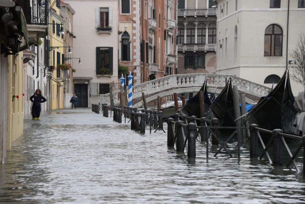 Венеция, която е построена на няколко острова, се справя с високата вода чрез издигането на платформи, за да могат хората да ходят