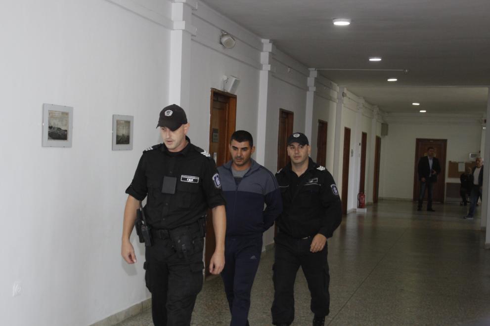 Полицаи конвоират до съдебната зала 39-годишния инспектор от ИАРА Янчо Георгиев.