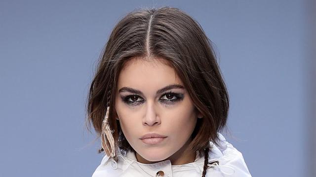 Кая Гербер пръска парфюма върху огледало, преди да го нанесе на себе си