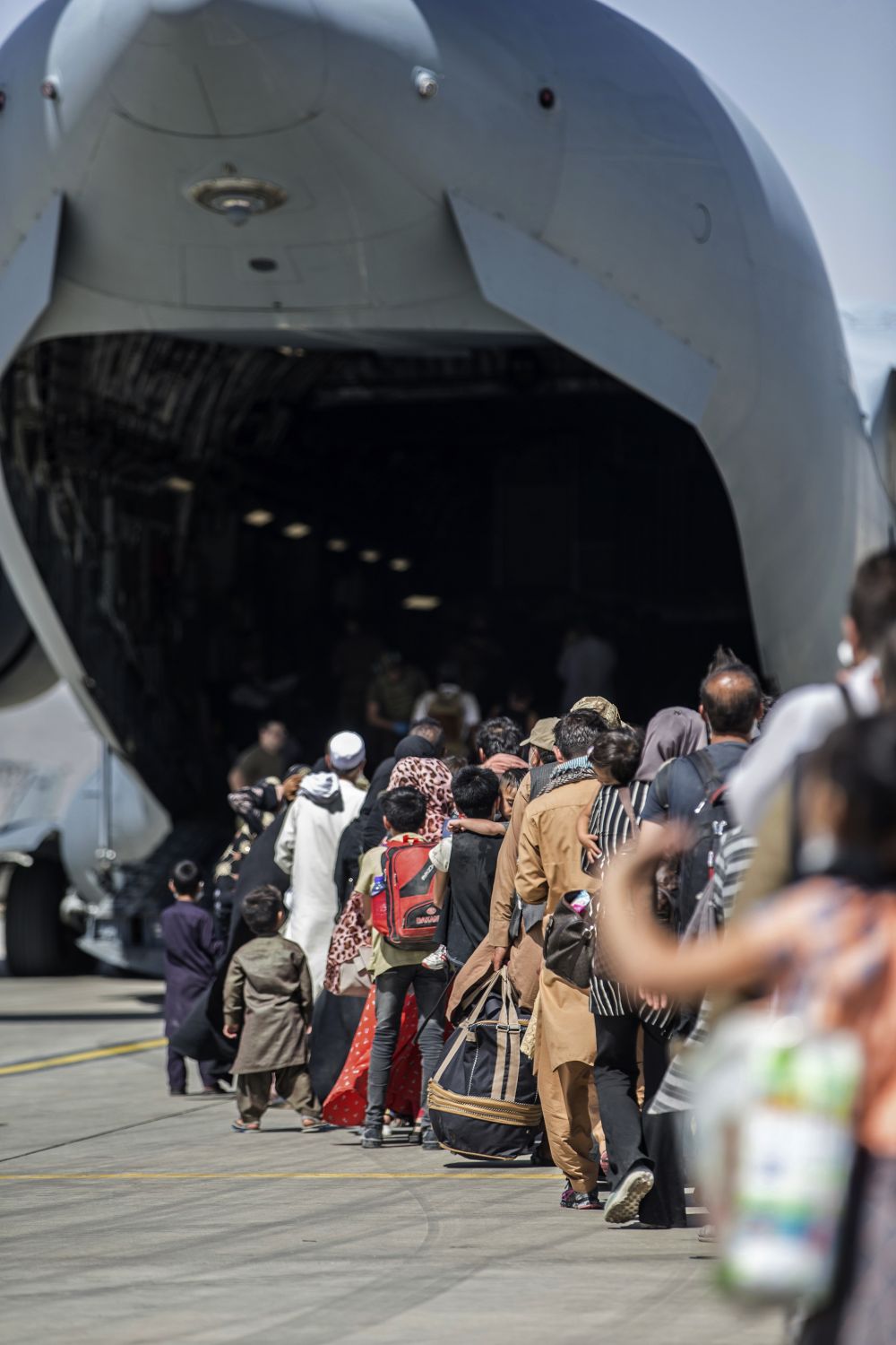 Семейства се качват на американски самолет, за да напуснат Афганситан
