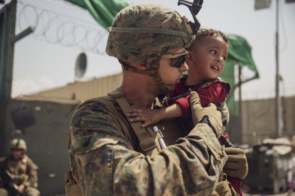 Американски военен успокоява малко плачещо дете по време на евакуацията от Кабул