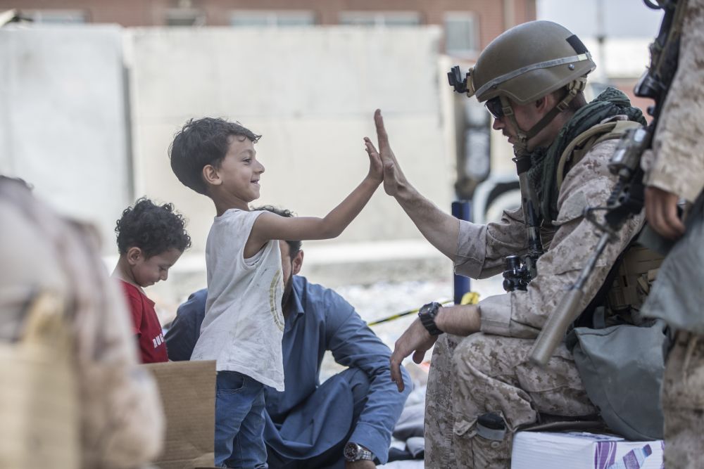 Афганистанче си играе с военен в очакване да бъде евакуирано със семейството му