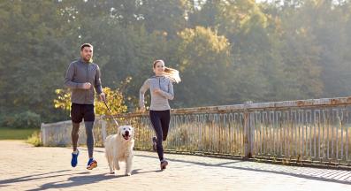 млада двойка тича с куче