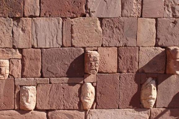  Главите на различни раси са по стените на храма в древния град.