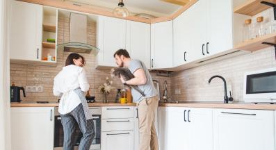 мъж и жена готвят в кухня с котка