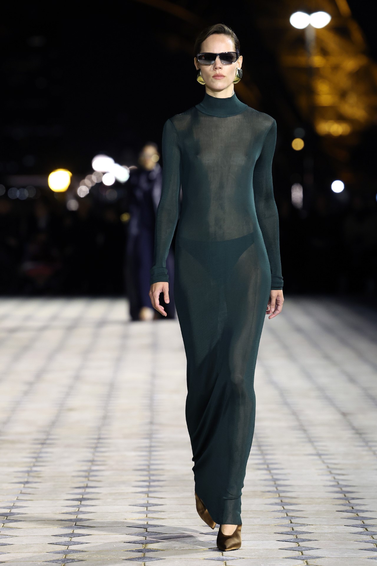 Френската модна къща "Ив Сен Лоран" организира дефиле на открит подиум, озарен от светещата Айфелова кула, за да представи колекция от елегантни вечерни облекла на дизайнера Антъни Вакарело