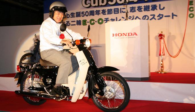  Соичиро Хонда върху Super Cub при честванията на 50-годишния юбилей на мотоциклета. Той е най-продаването МПС от 65 години