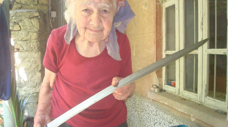 Покойната баба Каля показва тесака на отче Матея