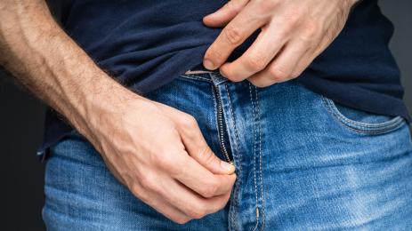 мъж разкопчава панталон