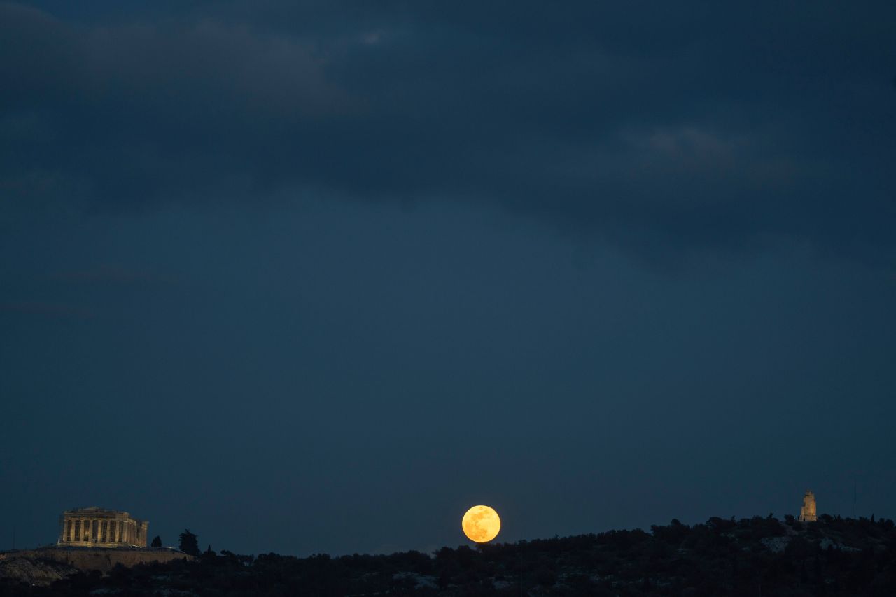 <p>Снежната луна изгрява зад хълма Филопап, между Партенона (вляво) и паметника Филопап (вдясно) в Атина, Гърция, на 12 февруари 2025 г.</p>