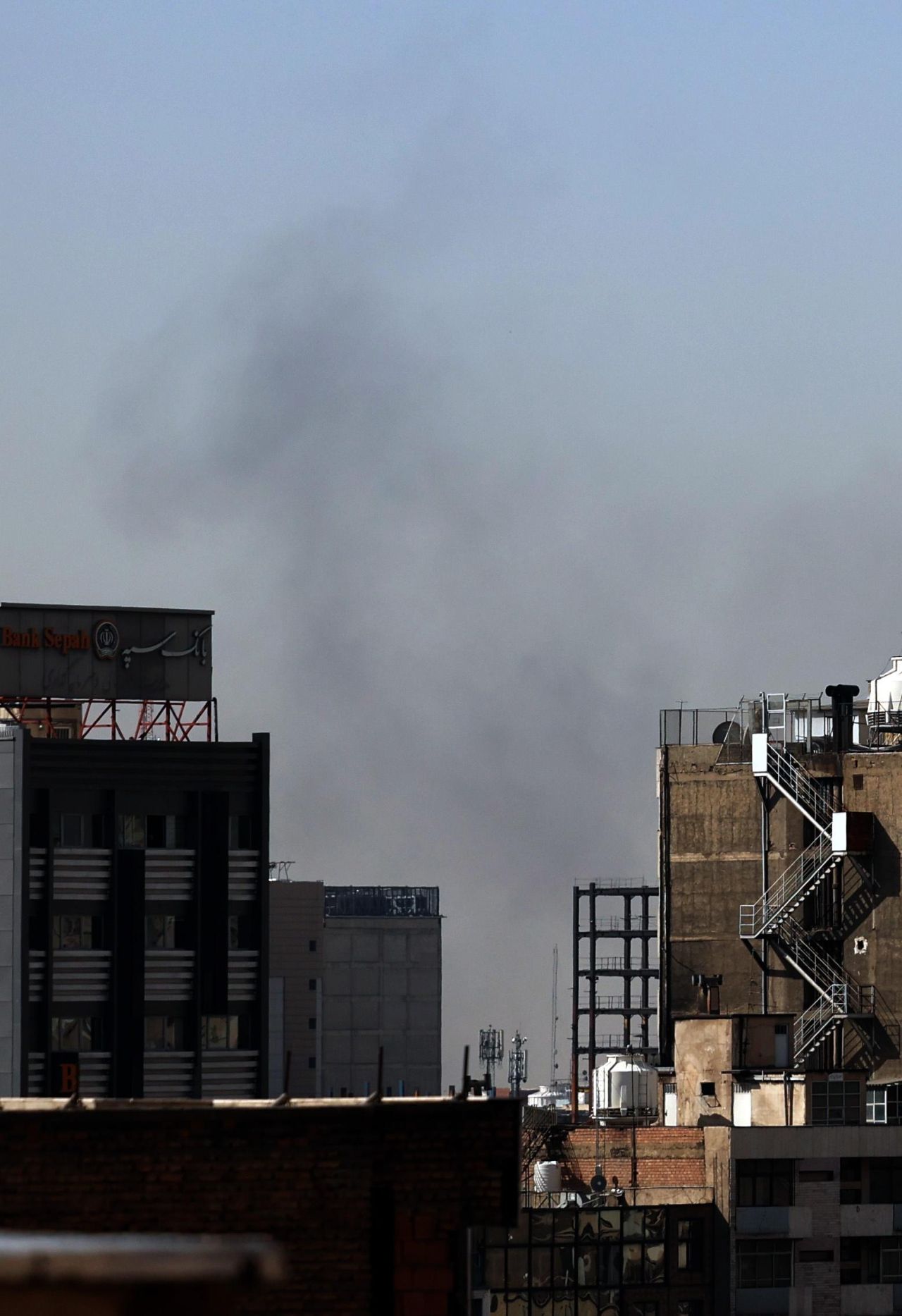 <p>Стълбове дим се издигат над Техеран след мощни експлозии в иранската столица тази събота, 28 февруари 2026 г. Доналд Тръмп потвърди началото на мащабна военна кампания на САЩ и Израел с цел пълно заличаване на ракетната индустрия на режима.</p>