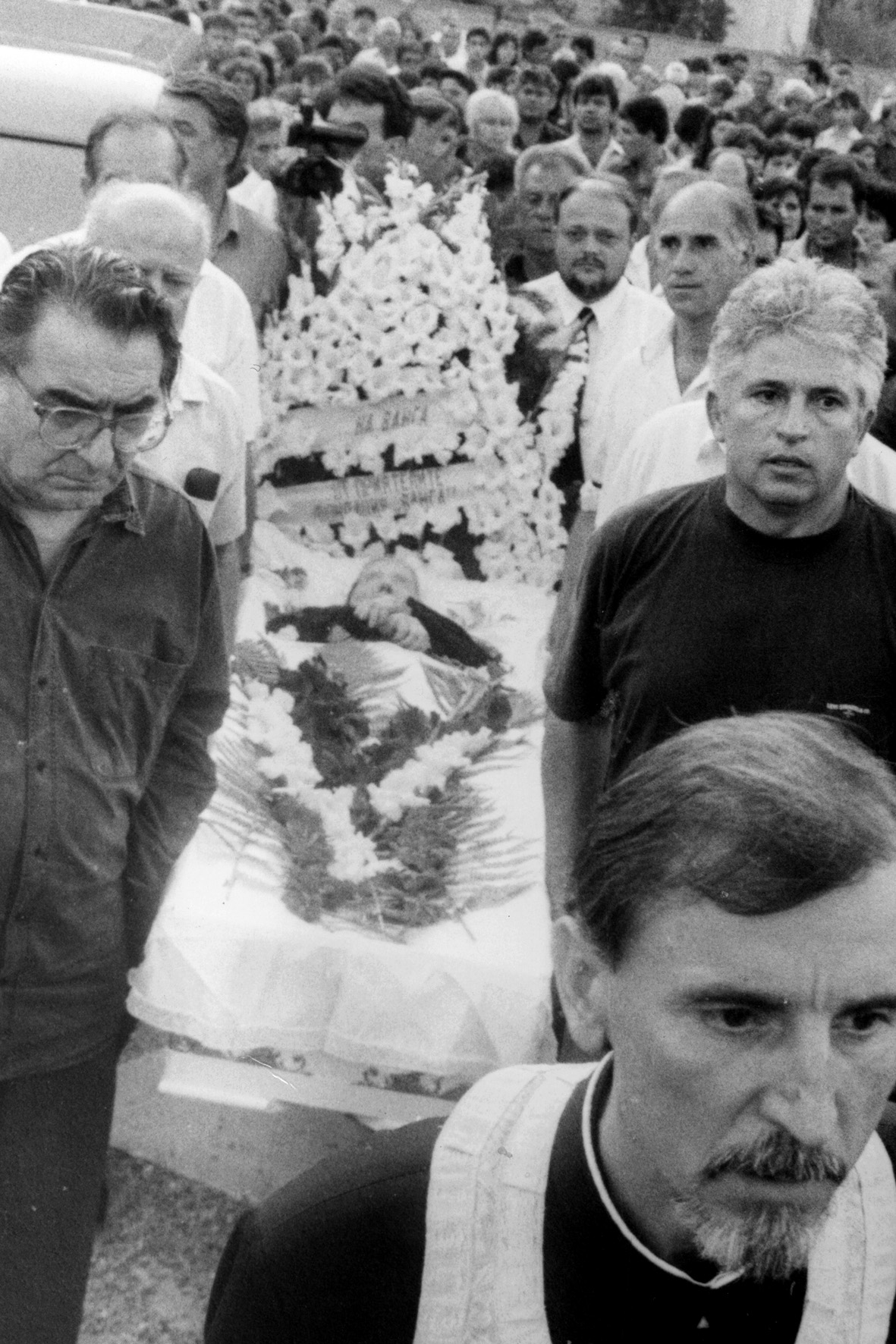 Внасяне саркофага с тялото на Ванга в построения от нея храм. Отпред са академик Светлин Русев и Димитър Вълчев. Шествието води свещеник Ангел Кочев. 11 август 1996 г.
&nbsp;