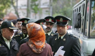 Нравствената полиция предупреждава жена по улиците на Техеран за непристойното и облекло.