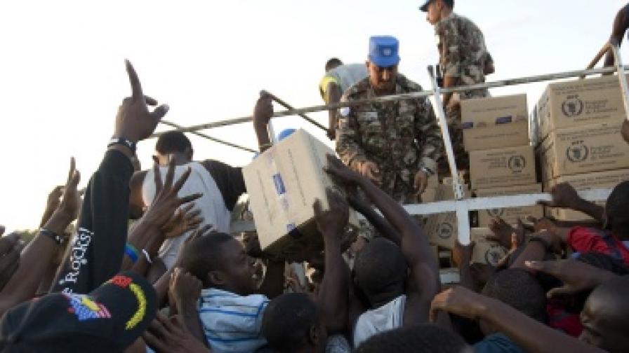 Служители на ООН раздават хуманитарна помощ на пострадалите от земетресението в Хаити
