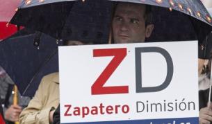 Мъж държи плакат, който призовава за оставката на премиера Сапатеро