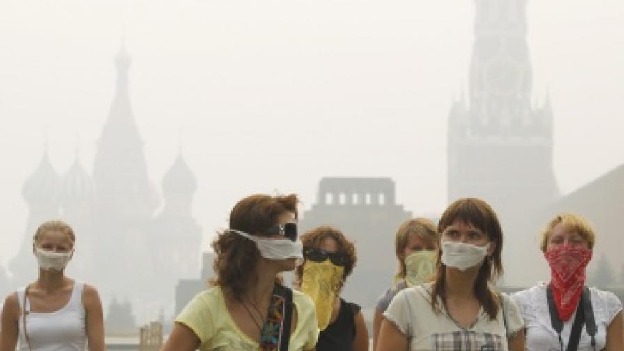 Туристи на Червения площад в Москва носят маски за предпазване от смога