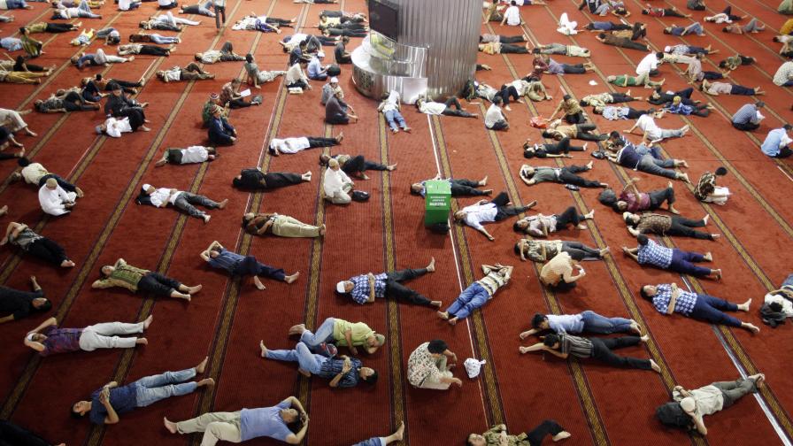 Индонезийски мюсюлмани почиват след петъчната молитва в третия ден от поста
