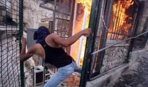 Палестинец до горяща къща на еврейски заселници в Източен Ерусалим