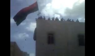 Въстаници развяват старо знаме на Либия от сграда в Бенгази (ЕПА разпространи тази снимка със забележка, че тя е от видеоклип в "ЮТюб" и агенцията не е в състояние да гарантира, че наистина е направена в Бенгази)